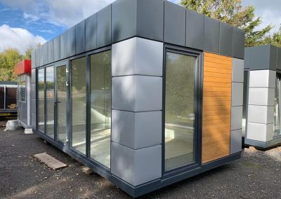 Portable Office with wooden cladding 600cm x 300cm (10ft x20ft) – Model 3 – Steel frame 80x80x3 mm; Galvanized steel; Roof, walls and floor insulated with 100mm Styrofoam; Aluminum double glazed: door, PVC opening window and 4 PVC fix windows;